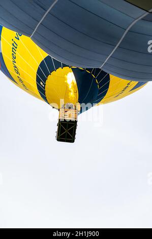 Vilnius, Lituania - 14 de septiembre de 2021: Un globo de aire caliente amarillo vibrante con un grupo de pasajeros se deshace al cielo en Vilnius, Lituania. Foto de stock