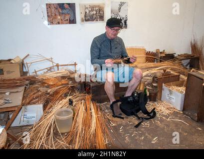 Camacha, Madeira, Portugal - 19 de abril de 2018: Un turista está tratando de hacer una cesta de mimbre en una tienda de fábrica en Camacha, Madeira, Portugal Foto de stock