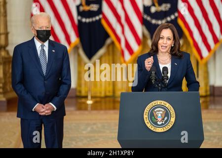 WASHINGTON DC, EE.UU. - 10 de agosto de 2021 - El Presidente de EE.UU. Joe Biden mira como Vicepresidente Kamala Harris pronuncia comentarios sobre la aprobación del bipartisa Foto de stock