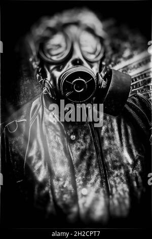 Persona que lleva un traje de peligro biológico con máscara de gas, de pie en la entrada de un túnel oscuro con bordes distorsionados y borrosos, en un tono blanco y negro