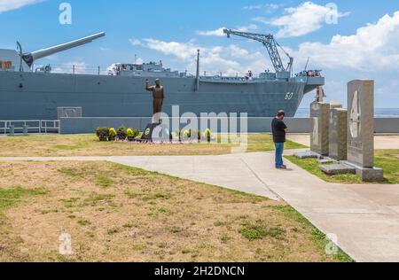 Visitante del parque que observa estatuas de granito en el acorazado del museo USS Alabama en el Battleship Memorial Park en Mobile, Alabama Foto de stock