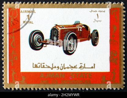 AJMAN - ALREDEDOR de 1973: Un sello impreso en Ajman muestra un viejo coche de carreras, alrededor de 1973