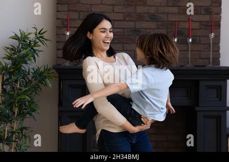 Feliz excitada mamá asiática que sostiene adoptó pequeño hijo en brazos Foto de stock