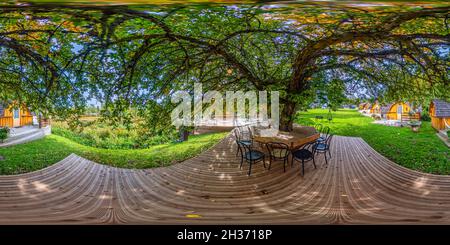 Vista panorámica en 360 grados de Terraza de madera bajo un manzano en una casa de vacaciones