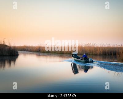 Pescadores en su barco en el canal de Oggau en el lago neusiedl en Burgenland Foto de stock