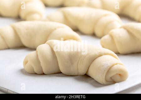 Proceso de preparación - raw sin horneado bollos. Masa de levadura  panecillos sobre papel para hornear, cerca. Estilo rústico. Repostería  tradicional Fotografía de stock - Alamy