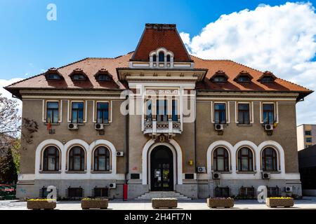 Bacau, Rumania, 02 de mayo de 2021: Foto delante del edificio simétrico de la oficina de correos, que tiene 2 banderas rumanas en las ventanas Foto de stock