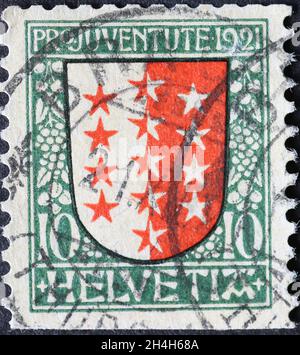 Suiza - Circa 1921: Sello impreso en Suiza con un escudo de armas rojo y blanco con estrellas del cantón suizo de Wallis Foto de stock