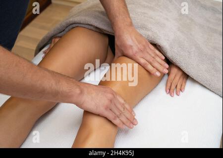 Mujer recibiendo piernas masaje de drenaje linfático en el salón de spa  primer plano relajación corporal belleza y cuerpo c