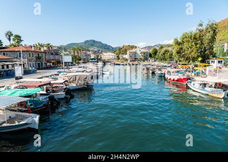 Marmaris, Mugla, Turquía – 30 de septiembre de 2020. Frente al mar en la ciudad turística de Marmaris. Vista con barcos de pesca, propiedades comerciales y personas. Foto de stock