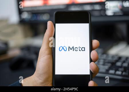 Joven usando la nueva aplicación Meta en un smartphone, logotipo de Facebook rebranding, aplicaciones metaverse