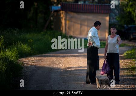 BOROVSK, RUSIA - 31 2013 DE MAYO: Un hombre y una mujer alcohólica charlando en la calle.
