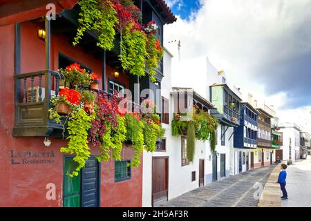 Santa Cruz de La Palma, Islas Canarias, España - 8 de diciembre de 2019: Niño pequeño mirando a coloridas casas antiguas con balcones de madera. Foto de stock