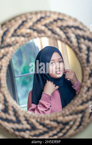 Chica usando su hijab en el espejo Foto de stock