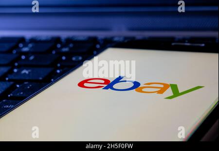 Smartphone en un teclado de ordenador con el logotipo de Ebay Foto de stock