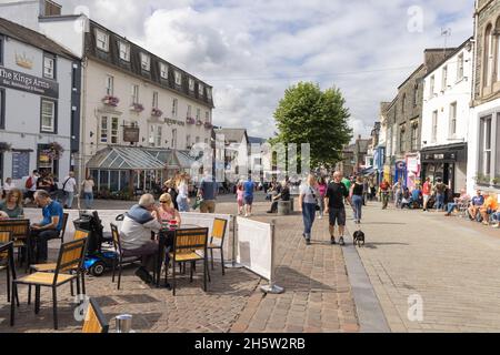 Keswick, Distrito de los Lagos; gente en el centro de la ciudad de Keswick en un día soleado en verano, Keswick Cumbria Reino Unido Foto de stock
