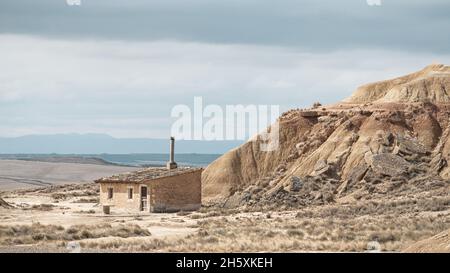 Viejo pliegue de ovejas en el semi-desierto de Bardenas Reales bajo un azul nublado rodeado de formaciones rocosas