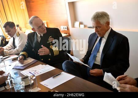El capitán de la Marina de los Estados Unidos, Bill Cox, centro, informa al secretario de Defensa, Chuck Hagel, a la derecha, mientras se prepara para visitar a altos funcionarios gubernamentales en Tbilisi, Georgia, el 7 de septiembre de 2014.