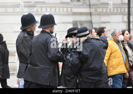 Cuatro oficiales de policía uniformados metropolitanos en servicio en Westminster, Londres. Dos oficiales de policía femeninos y dos hombres están juntos manteniendo una conversación. Foto de stock