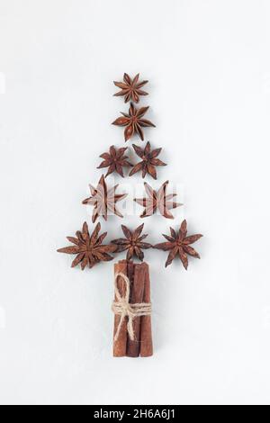 árbol de año nuevo hecho de estrellas de anís y palos de canela, fondo blanco, vista superior Foto de stock