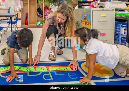 Una maestra de pre-kindergarten ayuda a sus estudiantes a arreglar números por dos, el 18 de mayo de 2012, en Columbus, Mississippi. (Foto de Carmen K. Sisson/Cloudybright Foto de stock