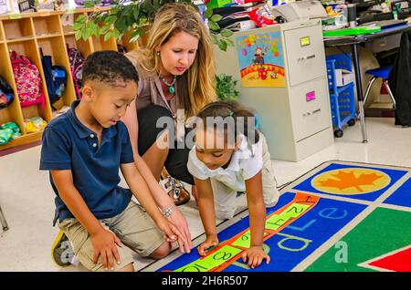 Una maestra de pre-kindergarten ayuda a sus estudiantes a arreglar números por dos, el 18 de mayo de 2012, en Columbus, Mississippi. (Foto de Carmen K. Sisson/Cloudybright Foto de stock