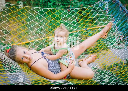 los niños se encuentran en una hamaca en el jardín Foto de stock
