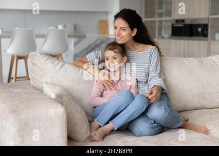 Sonriente mujer soñadora con linda hija niño visualizando el futuro Foto de stock