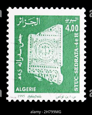 MOSCÚ, RUSIA - 25 DE OCTUBRE de 2021: Sello postal impreso en Argelia muestra pared que cubre, estucos de la ciudad en ruinas serie Sedrata, alrededor de 1995 Foto de stock