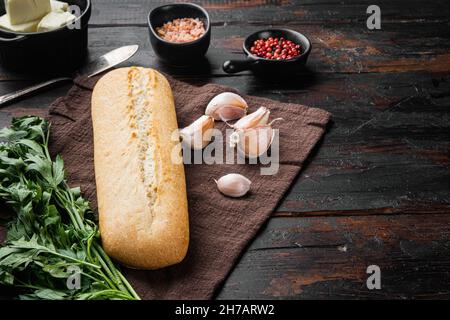 Conjunto de ingredientes compuestos de mantequilla y hierbas de pan de ajo, sobre fondo de mesa de madera oscura antigua, con espacio de copia para texto Foto de stock