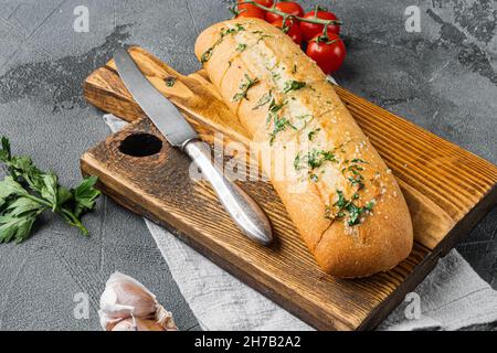 Conjunto de mantequilla de hierbas compuesta rellena de pan de ajo, sobre fondo de mesa de piedra gris Foto de stock