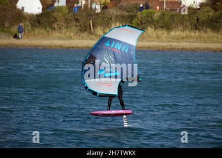 Persona windsurf que se apresará en el río Adur en Shoreham viajando en avión y fuera del agua. Foto de stock