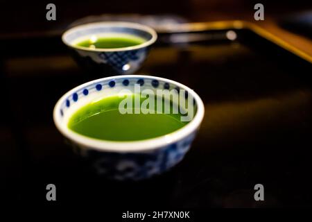 Casa tradicional japonesa con dos tazas de té romántico con matcha o té verde mora en ryokan con bandeja de mesa de madera lacada negra en la habitación Foto de stock