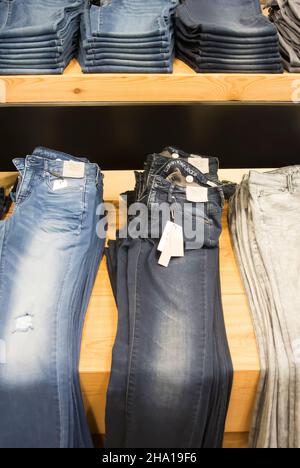 Jeans mostrados en los estantes para la venta Foto de stock