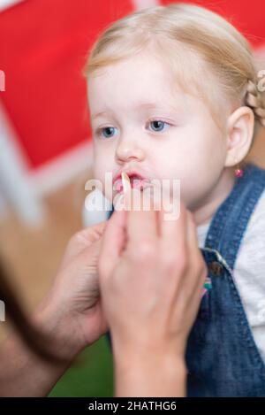 La terapeuta del habla de la mujer ayuda a la niña a corregir su habla en su oficina Foto de stock
