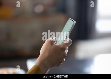 Enfoque de cerca en el smartphone en manos femeninas. Foto de stock