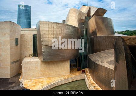 Fuera del Museo Guggenheim de Bilbao, reflejado en el río Nervión, Bilbao, País Vasco, España