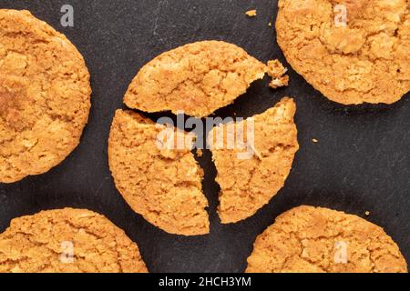 Varias galletas caseras dulces en piedra de pizarra, macro, vista superior.