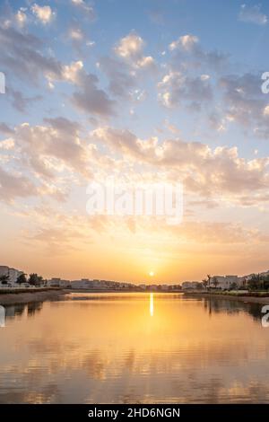 Puesta de sol sobre un lago en Emirates Hills en Dubai en los Emiratos Árabes Unidos. Foto de stock