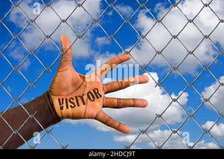 Die Hand eines Migranten hinter einem Maschendrahtzaun, Loch, Schlupfloch, Hilfe, Flüchtling, Asyl, Migrante, Migración, Ausländer, Schwarz, Afrikaner,