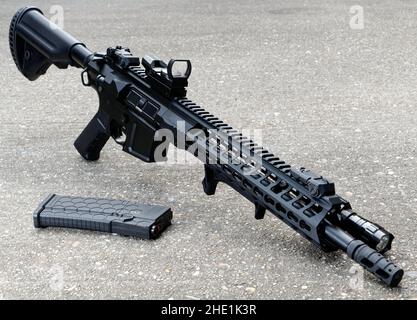 Airsoft réplica M4-M16 estilo rifle, independiente sobre hormigón. Foto de stock