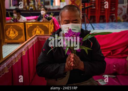 Bangkok, Tailandia. 1st de Ene de 2022. El hombre tailandés se sienta después de acostarse en un ataúd durante el ritual de resurrección en el templo.Los devotos resucitaron en un ritual anual de Año Nuevo en Wat Takien, cerca de Nonthaburi. Este rito comienza con una oración seguida por los participantes cantando con hilos santos envueltos alrededor de su cabeza antes de acostarse en un ataúd para 'die' y ser limpiados. (Imagen de crédito: © Matt Hunt/SOPA Images via ZUMA Press Wire)