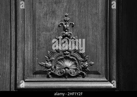 Antigua puerta de madera con tallado floral. París, Francia. Foto histórica en blanco negro Foto de stock
