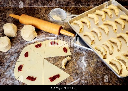 Elaboración de galletas de croissant caseras rellenas de mermelada. Foto de stock