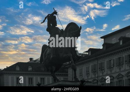 Contraluz de la estatua ecuestre de Emmanuel Philibert, duque de Saboya, contra el cielo de la puesta de sol en la plaza de San Carlo, Turín, Piamonte, Italia Foto de stock
