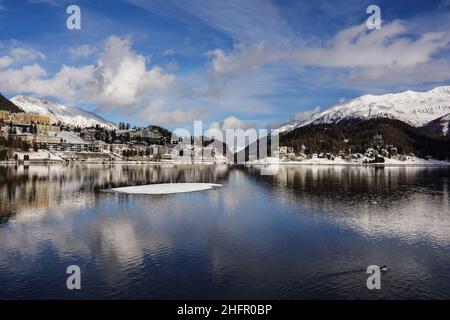Reflejo dramático del famoso pueblo de Saint Moritz en el lago en un soleado día de invierno en el Cantón Graubunden en los alpes en Suiza Foto de stock