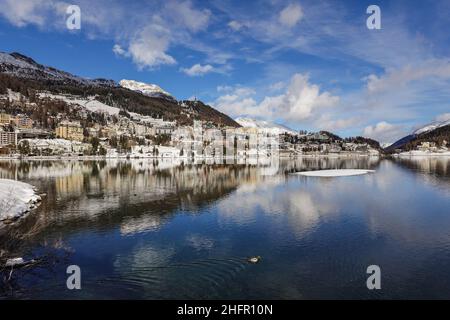 Reflejo dramático del famoso pueblo de Saint Moritz en el lago en un soleado día de invierno en el Cantón Graubunden en los alpes en Suiza Foto de stock