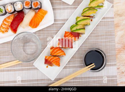 Rollos de sushi variados en platos en tabl Foto de stock