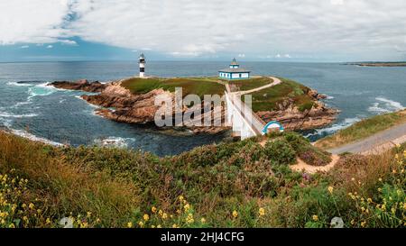 Pintoresco paisaje de costa verde con faro situado cerca de azul océano en  Faro Illa Pancha en Galicia en España en noche Fotografía de stock - Alamy