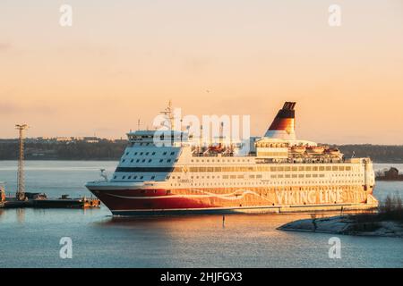 Helsinki, Finlandia. Vista de la moderna línea Viking del ferry que flotan cerca de la isla de Blekholmen Valkosaari en Sunrise Sky.